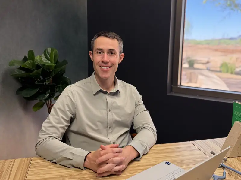 Taylor Cushman, MD, at his desk by a window looking out on the desert.